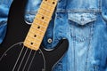 Black bass guitar on vintage denim jeans jacket for music background Royalty Free Stock Photo