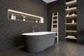 Black bathtub and brick wall, shelves with gels and plants, dark floor