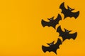 Black bats with eyes on a yellow background. Copy space