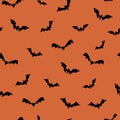 Black bats seamless repeat pattern for october holidays on orange background. Vector illustration, decoration.