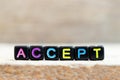 Black bead with letter in word accept on wood background