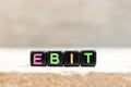 Black bead with letter in word EBIT Abbreviation of Earnings Before Interest and Taxes on wood background Royalty Free Stock Photo