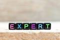 Black bead with letter in word expert on wood background