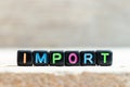 Black bead with letter in word import on wood background