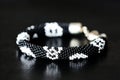 Black beaded bracelet with skull image on a dark background