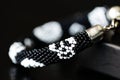 Black beaded bracelet with skull image on a dark background