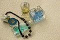 Glass bottles with colored perfume and black beads on a gray background Royalty Free Stock Photo