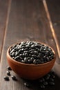 Black beans in ceramic bowl on dark wooden background Royalty Free Stock Photo