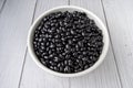 Black beans in white bowl on white wood background. top view. vegan food concept Royalty Free Stock Photo