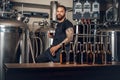 Black bearded maler presenting craft beer in the microbrewery. Royalty Free Stock Photo