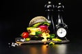 Black beef burger with flowing melted cheese and clock on a black background. Royalty Free Stock Photo