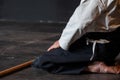 Black belt aikido master in seiza traditional sitting.