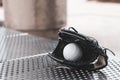 Black bestball glove holding a white baseball and placed on the stainless steel bench Royalty Free Stock Photo