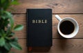 Black bible and coffee cup rest on wood table. Morning routine for spiritual study and quiet reflection. Holy scripture Royalty Free Stock Photo