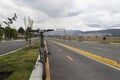 A black bicycle into a bike path near to a new street at city outdside with mountains and buildings at background