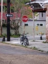 Black bicycle at corner of road by red stop sign Royalty Free Stock Photo