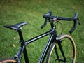 black bicycle in field of grass detail from behind (road bike with drop handlebars, tires) cyclocross gravel bike sleek Royalty Free Stock Photo