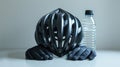 Black bicycle helmet, gloves, and water bottle on a white surface. Royalty Free Stock Photo