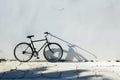 Black Bicycle Leaning Against a White Wall in Bright Sunlight Royalty Free Stock Photo