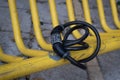 Black bicycle safety locker on a yellow pole of a bike parking