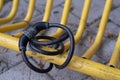 Black bicycle safety locker on a yellow pole of a bike parking