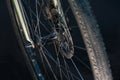 A black bicycle wheel with a tire close-up on a black background. Maintenance and repair of bicycles before responsible Royalty Free Stock Photo