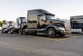 Black big rig powerful semi truck transporting coupled another semi tractors Royalty Free Stock Photo