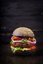 Black big sandwich - black hamburger with juicy beef burger, cheese, tomato, and red onion Royalty Free Stock Photo