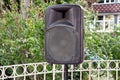 Black big speaker on stand outdoor / A big p.a. speaker on a stage at an outdoor music festival / Large audio speaker.
