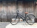 Black bike brown cushion The front door of the house and the old wooden wall is not painted with a simple life concept, exercise, Royalty Free Stock Photo