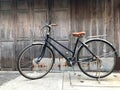 Black bike brown cushion The front door of the house and the old wooden wall is not painted with a simple life concept, exercise, Royalty Free Stock Photo