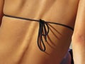 Black Bikini String Knot Closeup on Back of Attractive Beautiful Woman with Visible Spine Backbone Royalty Free Stock Photo