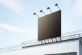 Black billboard with copyspace with backlights on industrial building rooftop outdoor at blue sky background. 3D rendering, mockup Royalty Free Stock Photo