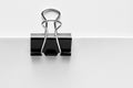 Black binder clip attached to the corner of a blank white paper Royalty Free Stock Photo