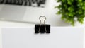 Black binder clip on white surface Royalty Free Stock Photo