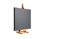 Black blank cotton canvas stretched on subframe and a wooden table easel, isolated on white