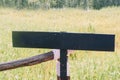 A black blank sign made of wooden as a copy space ready to put text on it with rice field in the background Royalty Free Stock Photo