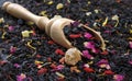 Black blended tea with flower petals and dried fruit on a wooden scoop. close up Royalty Free Stock Photo