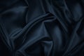 Black blue abstract background. Dark blue silk satin texture. Beautiful wavy soft folds on the surface of the fabric. Royalty Free Stock Photo