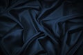 Black blue abstract background. Dark blue silk satin texture background. Beautiful wavy soft folds on the surface of the fabric. Royalty Free Stock Photo