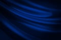 Black blue abstract background. Dark blue silk satin texture background. Shiny fabric with wavy soft pleats. Royalty Free Stock Photo