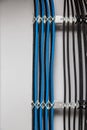 The black and blue cable wires are symmetrically secured with white cable ties to the metal cable tray, ladder on a Royalty Free Stock Photo