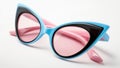 Black and blue retro cat eye sunglasses with pink frames on a white background, in a closeup view Royalty Free Stock Photo