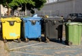 Black, blue, yellow, green garbage containers in city. Separate waste, preserve the environment concept. Segregate waste,