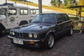Black BMW 318i E30 sedan in retro car meet