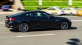 Black BMW 420i G22 coupe on the road in motion. Fast speed drive on city road. Side view of moving BMW 4 Series on the street Royalty Free Stock Photo