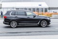 Black BMW X7 car moving on the street on high speed. Fast moving black SUV car on city motorway Royalty Free Stock Photo