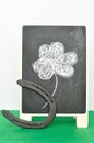 A black board with a four leaf clover and a horseshoe Royalty Free Stock Photo