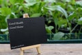 Black board on wooden plank for advertistment organic vegtable plant proucts,health food and living