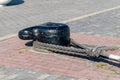 Black bollard on the harbor wall for attachment to the ship